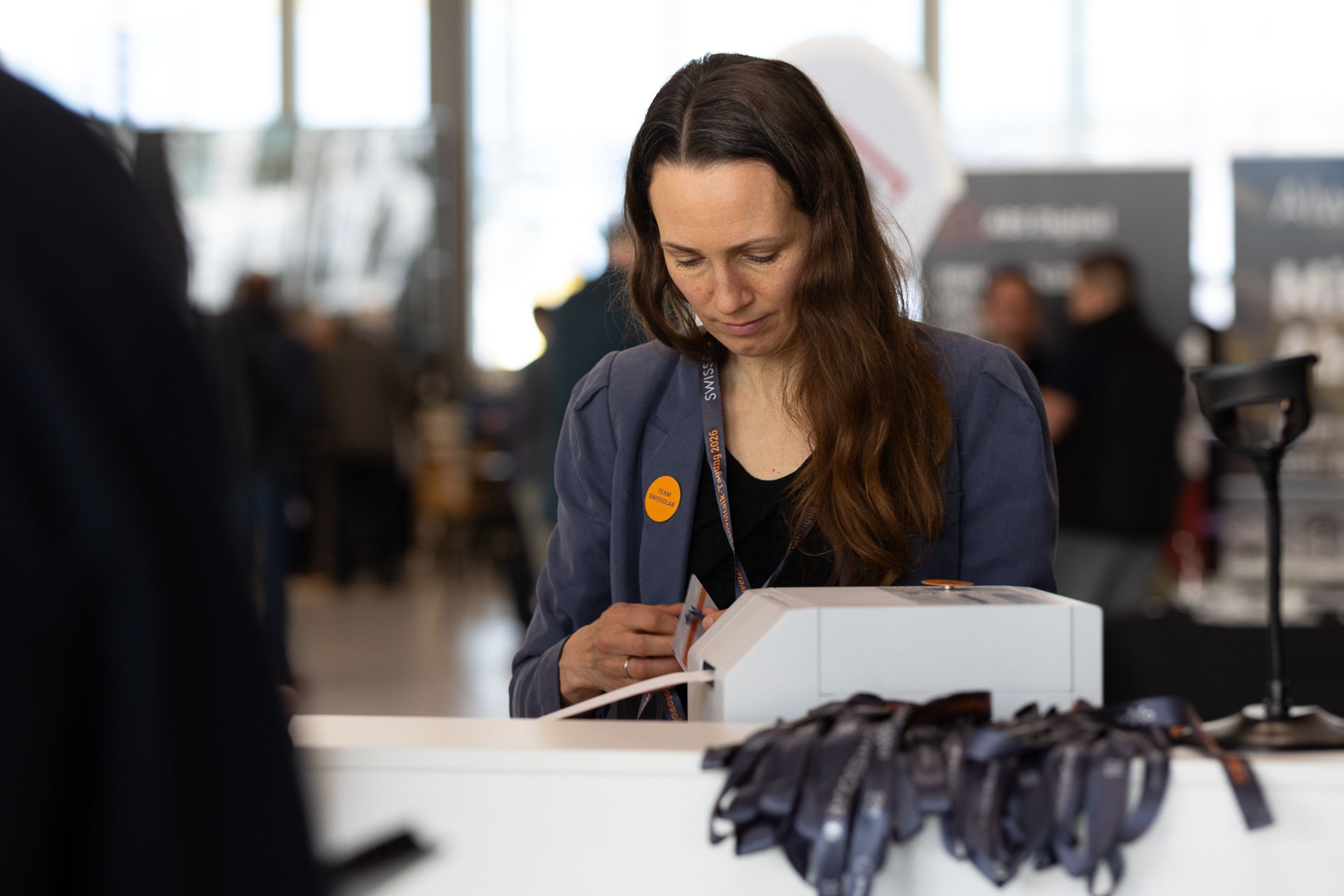 Frau mit blauen Jacket am Empfang  | © Swissolar / Sarah Bollmann, atelier olive GmbH
