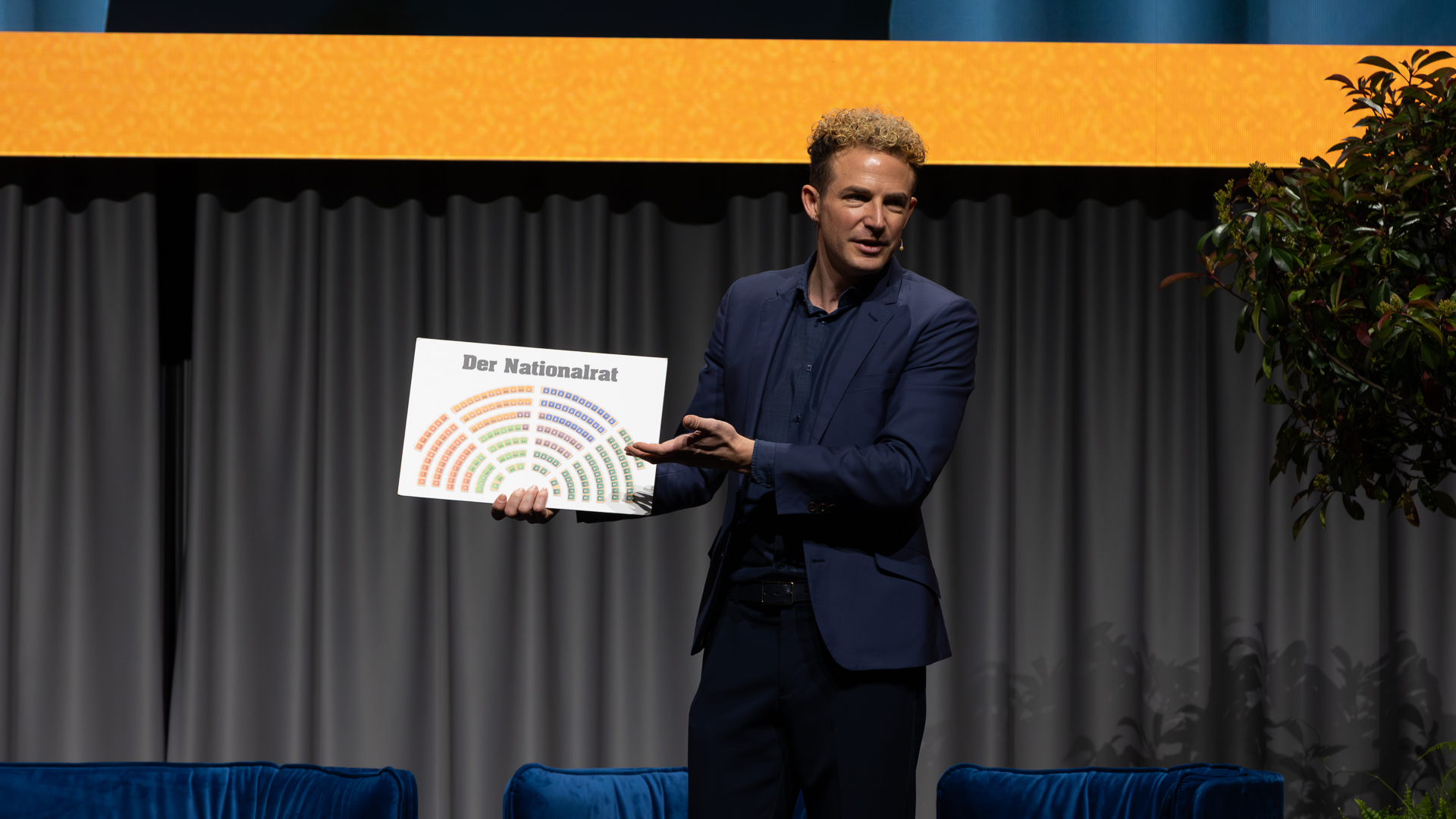 Mann in blauen Jacket mit weissen Schild in der Hand | © Swissolar / Sarah Bollmann